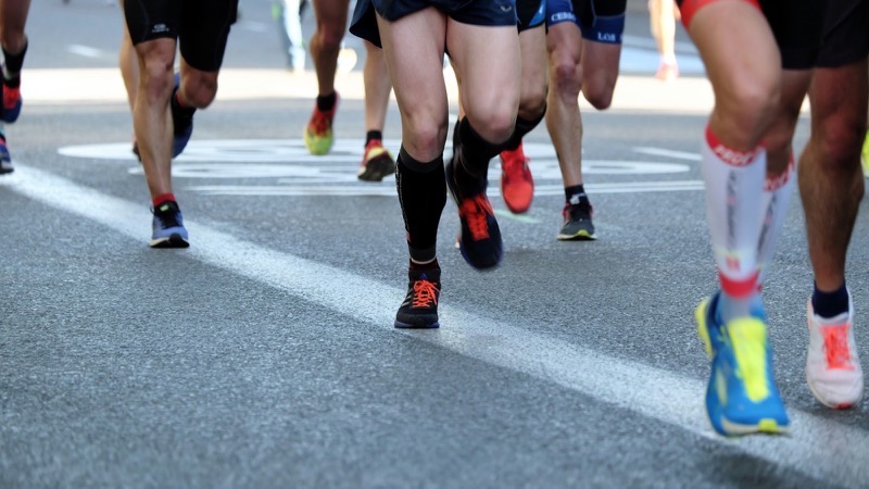 Jambes et chaussures de coureurs pendant une course, en gros plan